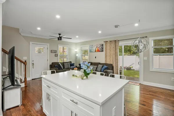 a view of a dining room with furniture a chandelier and wooden floor