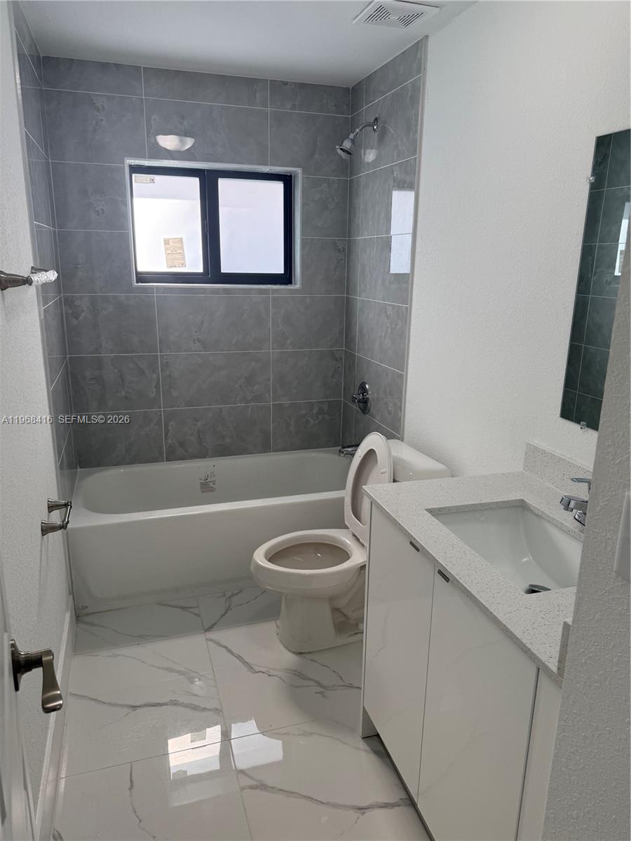 210 Southwest 3rd Street Florida City, FL 33034 - Photo 15 of 15 a bathroom with a granite countertop toilet a sink and bathtub