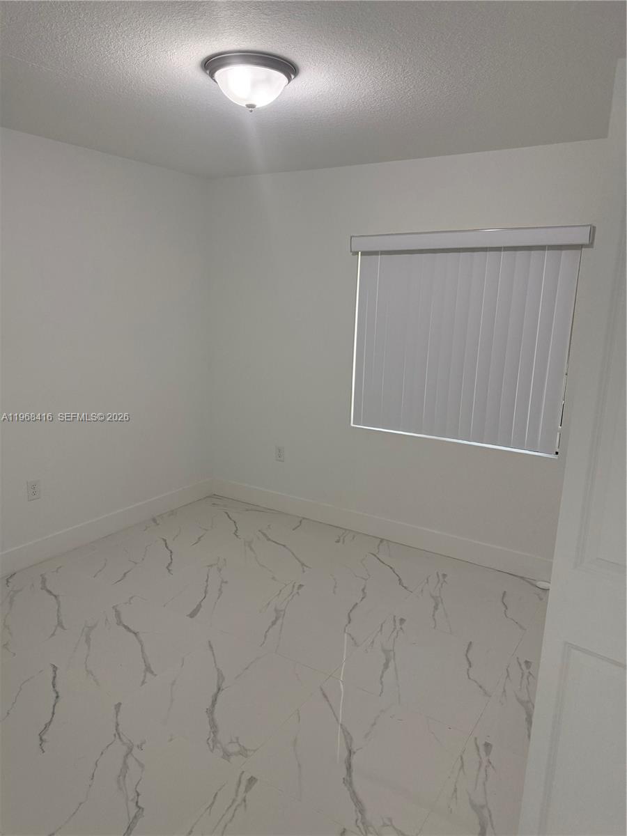 210 Southwest 3rd Street Florida City, FL 33034 - Photo 9 of 15 an empty room with a workbench