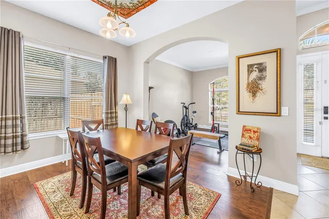 a dining room with furniture a chandelier and wooden floor