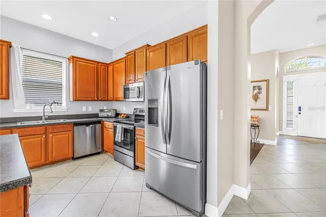 a kitchen with stainless steel appliances granite countertop a refrigerator and a sink