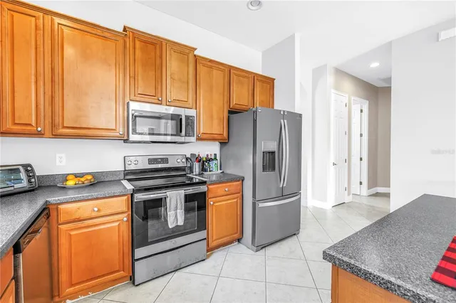 a kitchen with stainless steel appliances granite countertop a refrigerator stove and sink