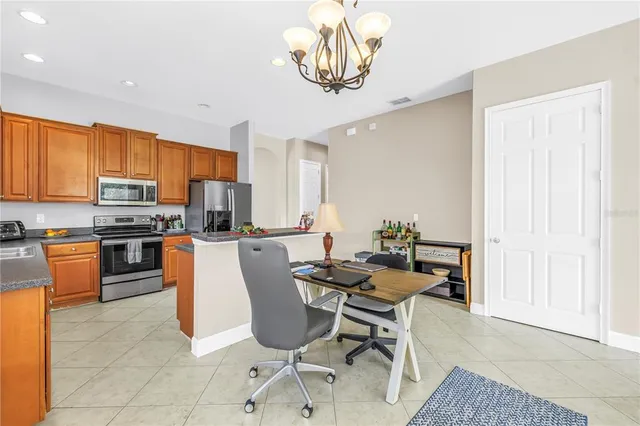 a kitchen with stainless steel appliances kitchen island granite countertop a refrigerator and a stove top oven