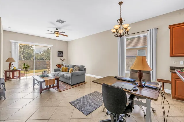 a living room with furniture a chandelier and a window