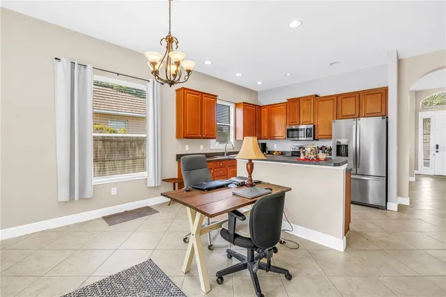 a kitchen with stainless steel appliances kitchen island granite countertop a refrigerator and a stove top oven