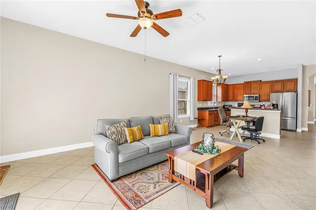 a living room with furniture kitchen view and a chandelier