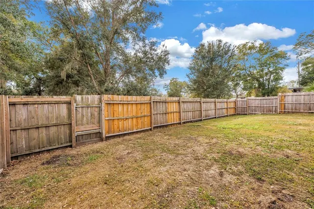 a view of backyard with wooden fence