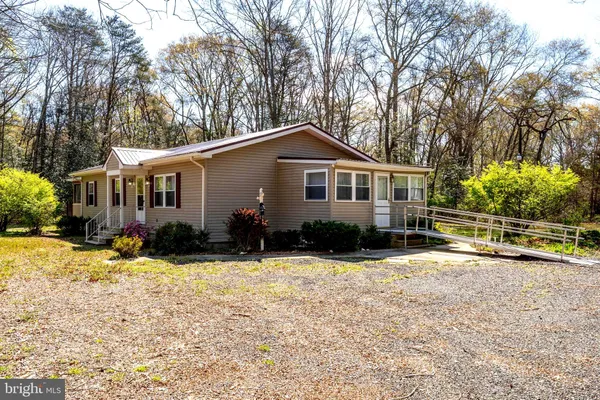 a front view of a house with a yard covered with trees