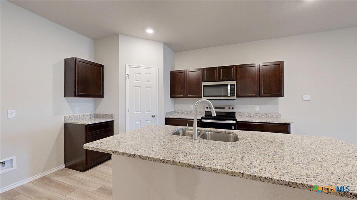 1111 Stone Vly Road Temple, TX 76502 - Photo 6 of 21 a kitchen with stainless steel appliances granite countertop a sink and a microwave