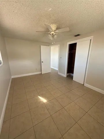 an empty room with a ceiling fan and glass door