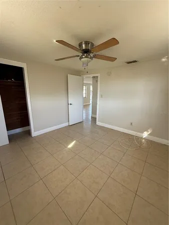 an empty room with a ceiling fan and carpet