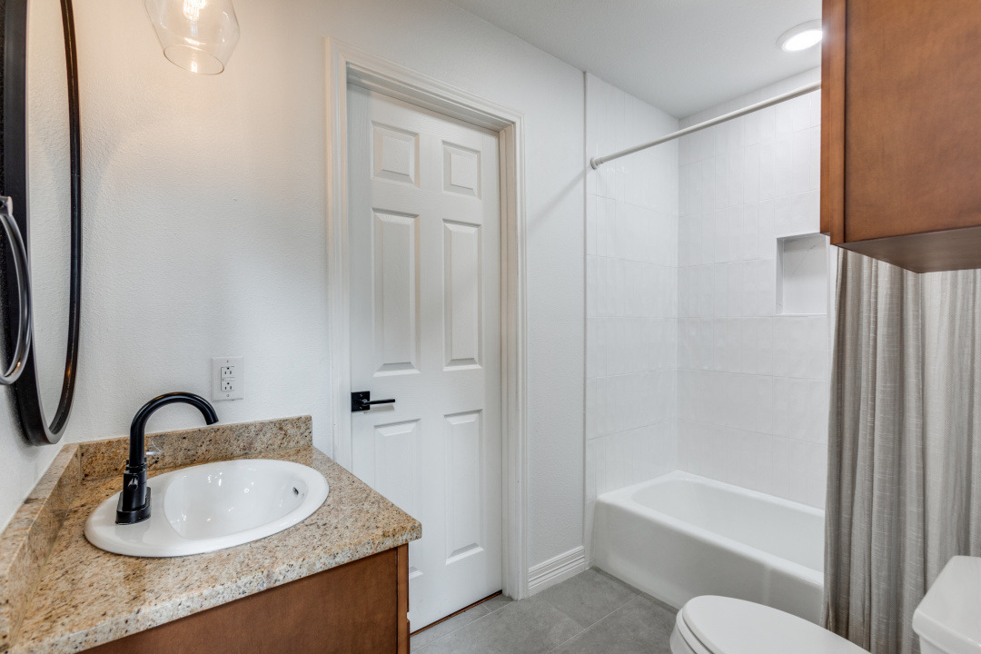 1113 Taulbee Lane Austin, TX 78757 - Photo 14 of 35 a bathroom with a granite countertop sink toilet and shower