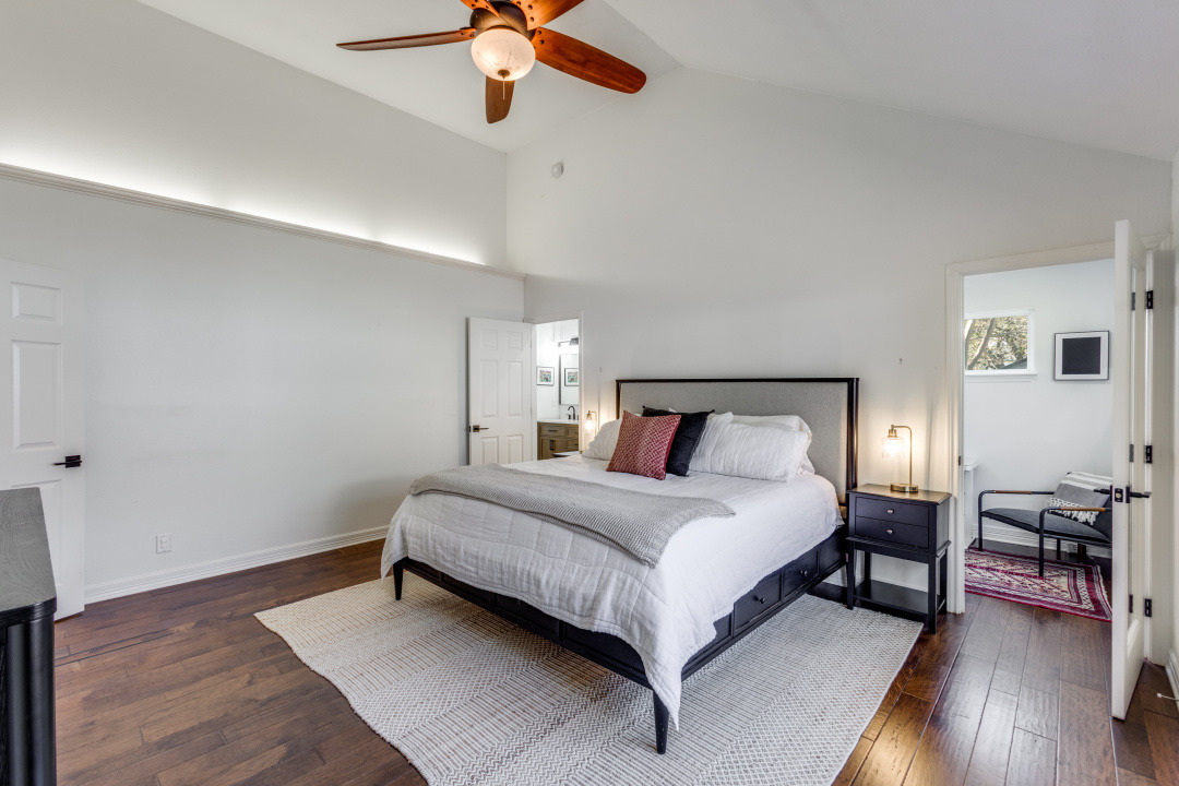 1113 Taulbee Lane Austin, TX 78757 - Photo 16 of 35 a spacious bedroom with a bed and a chandelier