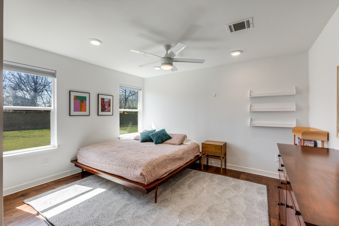 1113 Taulbee Lane Austin, TX 78757 - Photo 23 of 35 a bedroom with a bed and a chandelier