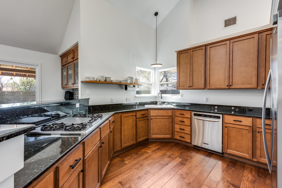 1113 Taulbee Lane Austin, TX 78757 - Photo 10 of 35 a kitchen with stainless steel appliances granite countertop a stove a sink dishwasher and cabinets with wooden floor