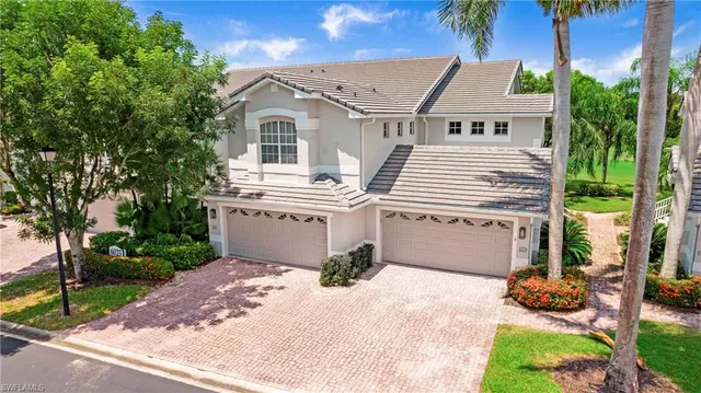 a view of a white house with a yard and potted plants
