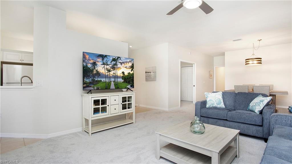 6025 Pinnacle Lane, Unit 6602 Naples, FL 34110 - Photo 12 of 43 a living room with furniture and a flat screen tv