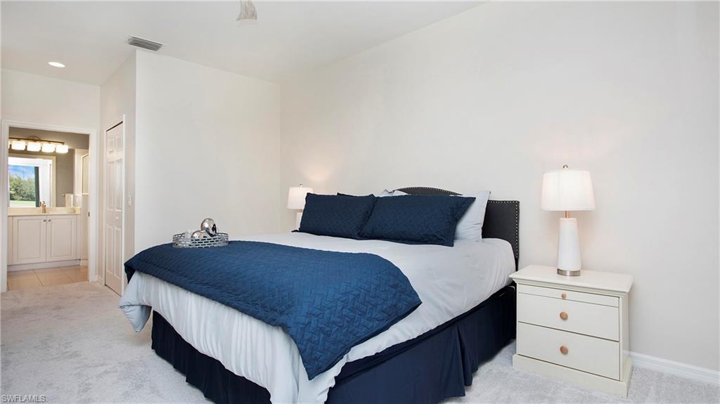 6025 Pinnacle Lane, Unit 6602 Naples, FL 34110 - Photo 15 of 43 a bedroom with a bed and a lamp