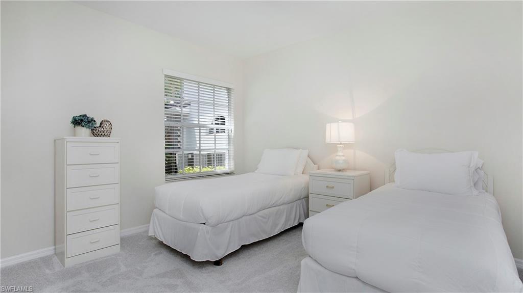 6025 Pinnacle Lane, Unit 6602 Naples, FL 34110 - Photo 18 of 43 a bedroom with two beds and a window