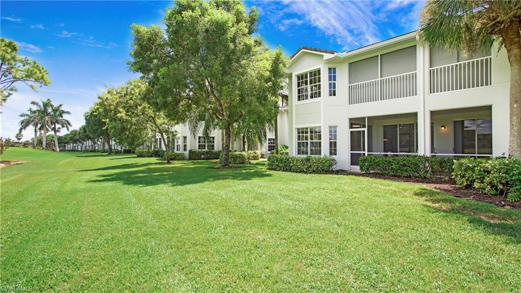 6025 Pinnacle Lane, Unit 6602 Naples, FL 34110 - Photo 26 of 43 a front view of a house with a yard
