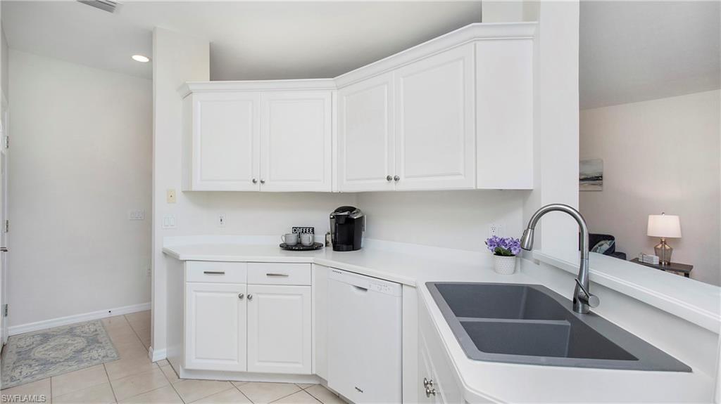 6025 Pinnacle Lane, Unit 6602 Naples, FL 34110 - Photo 5 of 43 a kitchen with white cabinets a sink and dishwasher