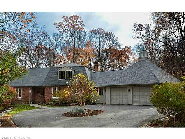 a front view of a house with a garden and trees