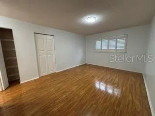 a view of empty room with wooden floor