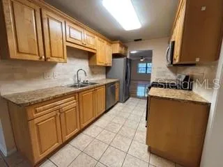 a kitchen with stainless steel appliances granite countertop a sink stove and cabinets
