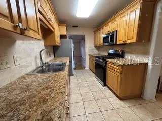 a kitchen with stainless steel appliances granite countertop a sink stove and cabinets