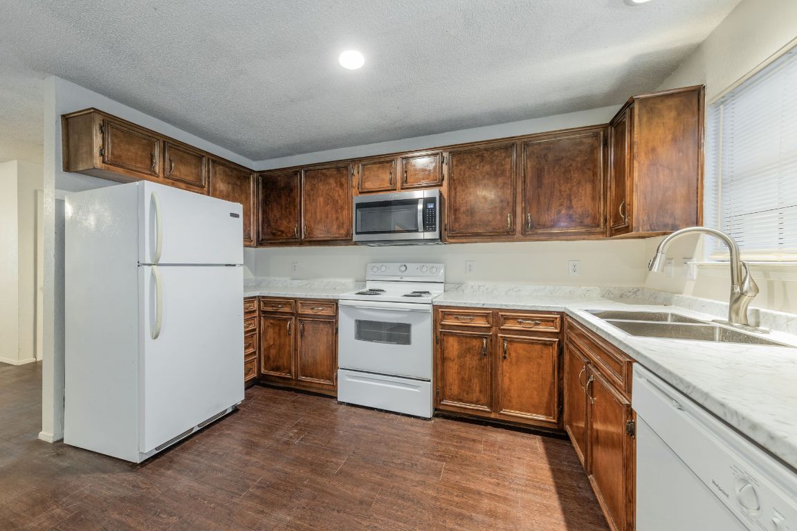 4518 Speedway, Unit B Austin, TX 78751 - Photo 3 of 7 a kitchen with stainless steel appliances granite countertop a refrigerator stove a sink dishwasher and microwave with cabinets