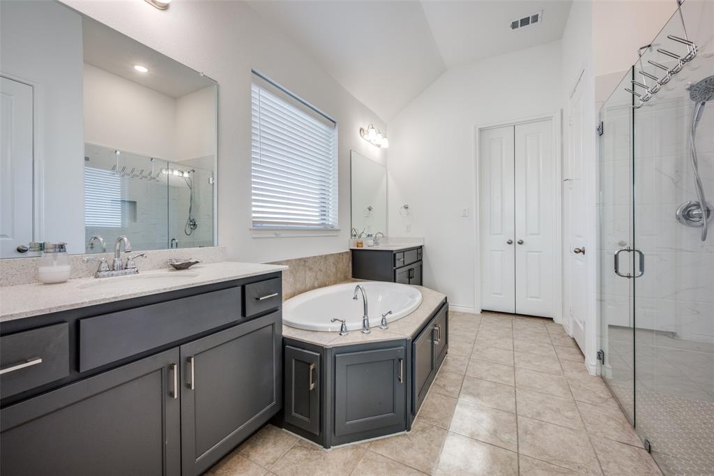 4804 Long Pond Trail Flower Mound, TX 76262 - Photo 13 of 22 a bathroom with a double vanity sink a mirror and a bathtub