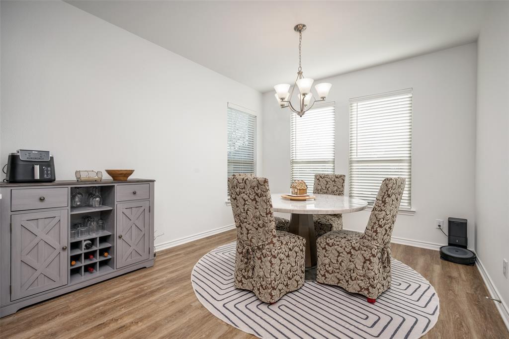 4804 Long Pond Trail Flower Mound, TX 76262 - Photo 10 of 22 a living room with furniture a dining table and a bookshelf with wooden floor