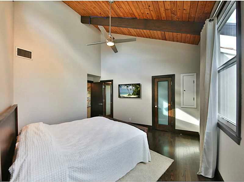 1 Seneca Road Sea Ranch Lakes, FL 33308 - Photo 9 of 35 a bedroom with a large bed and a chandelier