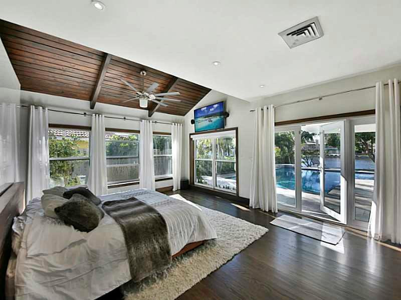 1 Seneca Road Sea Ranch Lakes, FL 33308 - Photo 23 of 35 a large bed sitting in a bedroom next to a large window