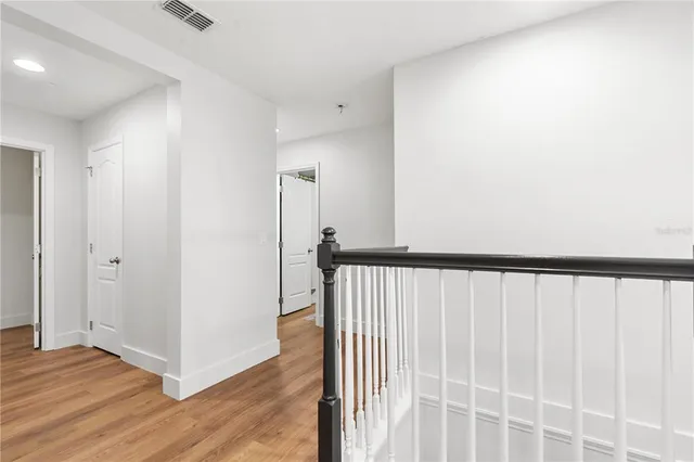 a bedroom with a large bed and wooden floor