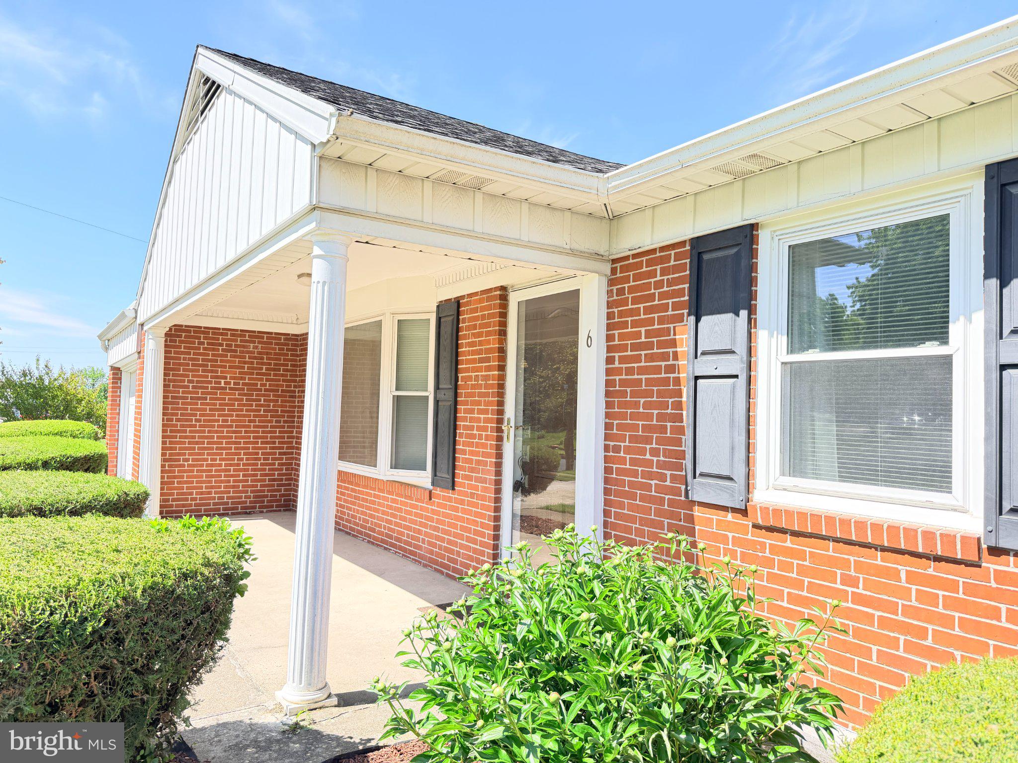 6 East Aylesbury Road Lutherville-Timonium, MD 21093 - Photo 2 of 19 Charming brick facade with lush greenery.
