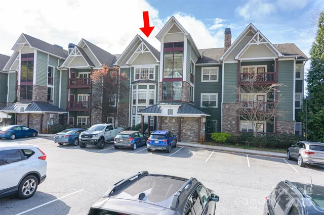 a car parked in front of a brick house with large windows