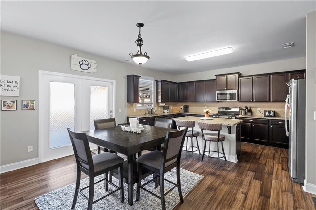 285 Paces Drive Lithia Springs, GA 30122 - Photo 13 of 45 a view of a dining room with furniture wooden floor and a rug