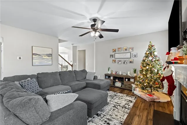 a living room with furniture a flat screen tv and a christmas tree