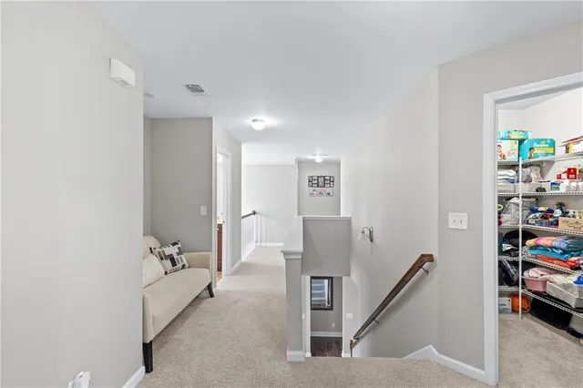 a view of a hallway with workspace and a couch