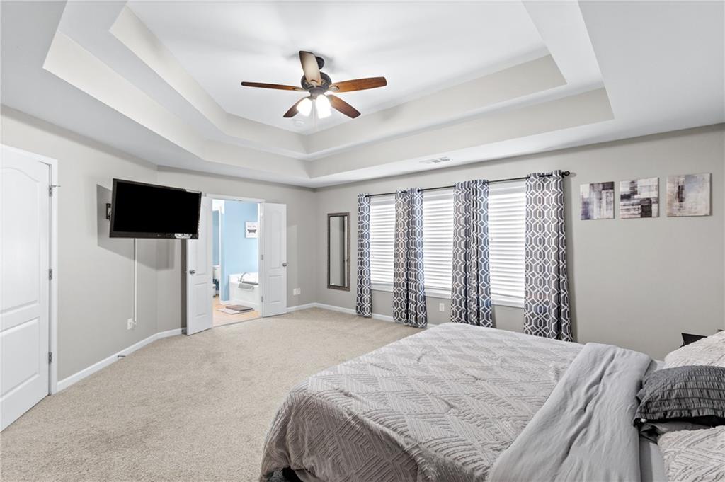 285 Paces Drive Lithia Springs, GA 30122 - Photo 25 of 45 a bedroom with a large bed and a flat screen tv