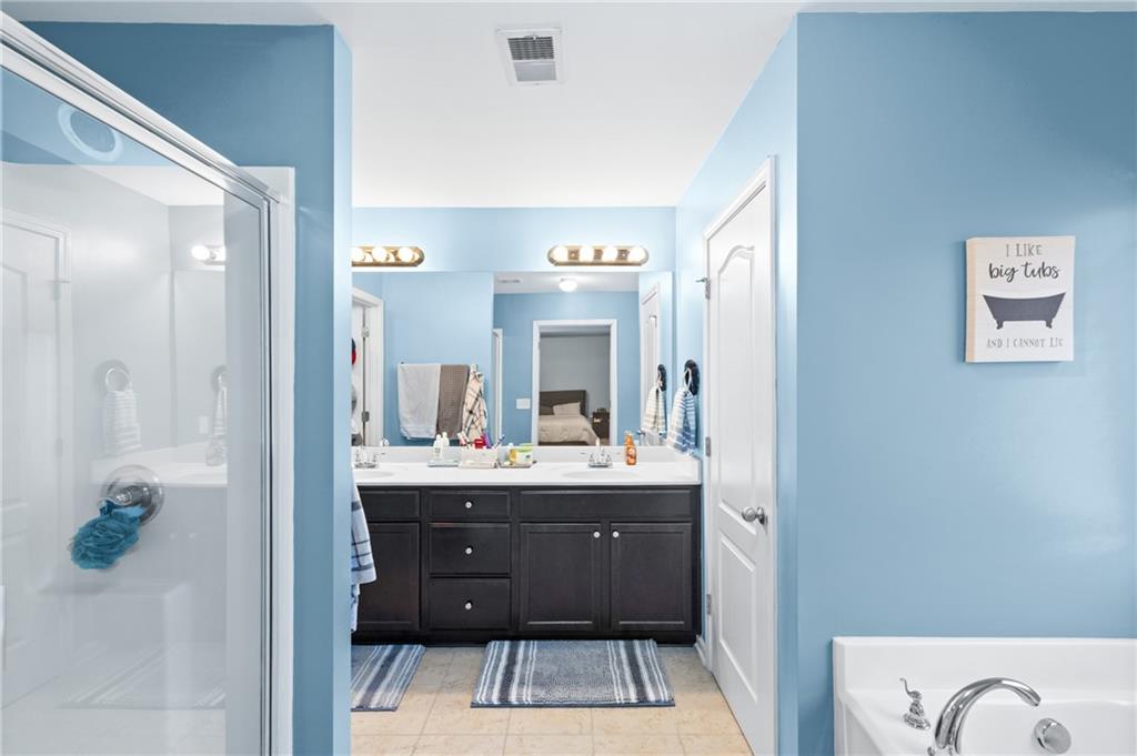 285 Paces Drive Lithia Springs, GA 30122 - Photo 26 of 45 a bathroom with a sink a mirror and a bathtub