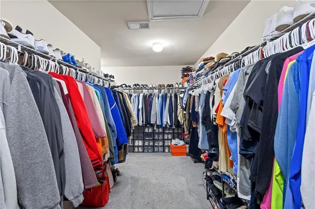 a view of walk in closet with clothes
