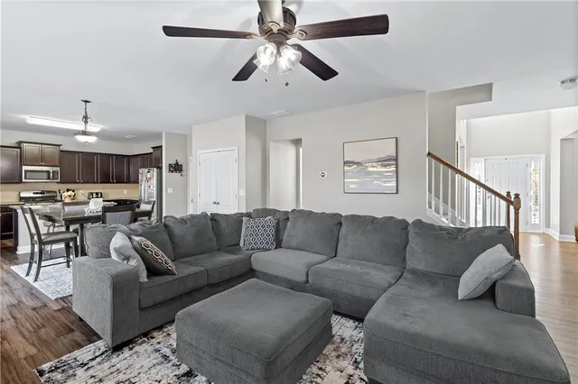 a living room with furniture and a view of kitchen