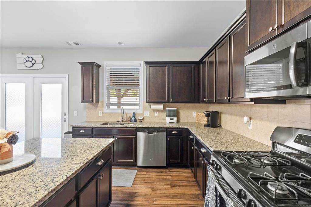 285 Paces Drive Lithia Springs, GA 30122 - Photo 9 of 45 a kitchen with stainless steel appliances granite countertop a sink stove and cabinets