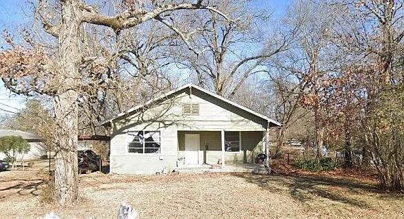 2154 Bonham Street Paris, TX 75460 - Photo 1 of 1 a front view of a house with a yard covered in snow
