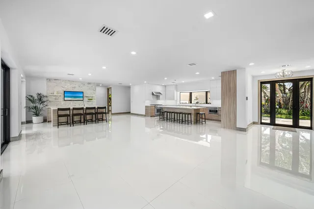 an empty room with windows and view of living room