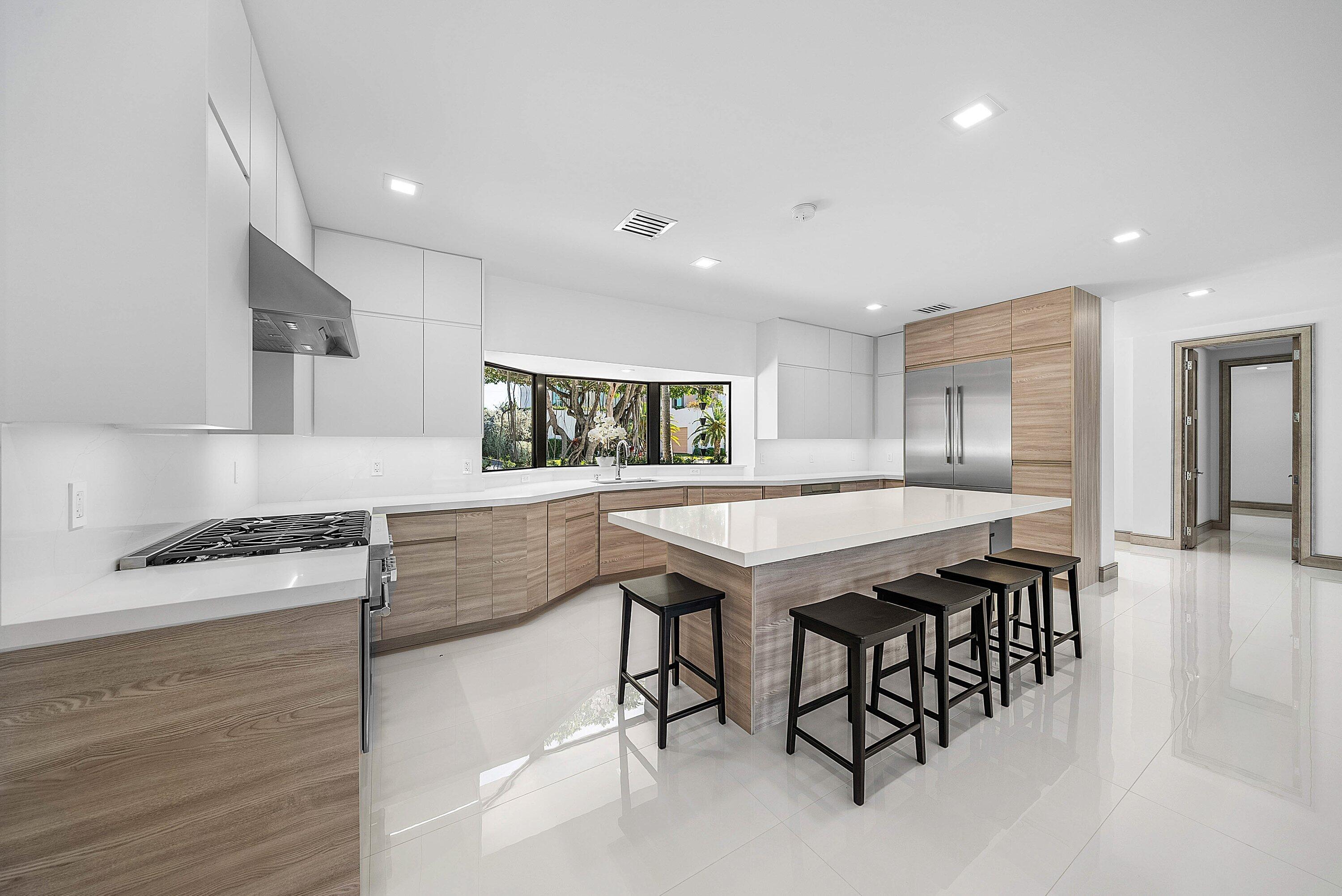 40 Spoonbill Road Manalapan, FL 33462 - Photo 22 of 67 a dining hall with stainless steel appliances granite countertop a stove a sink a refrigerator and white cabinets