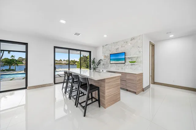 an empty room with ceiling fan and windows