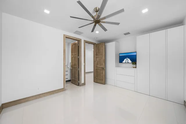 a spacious bedroom with a large bed and a chandelier